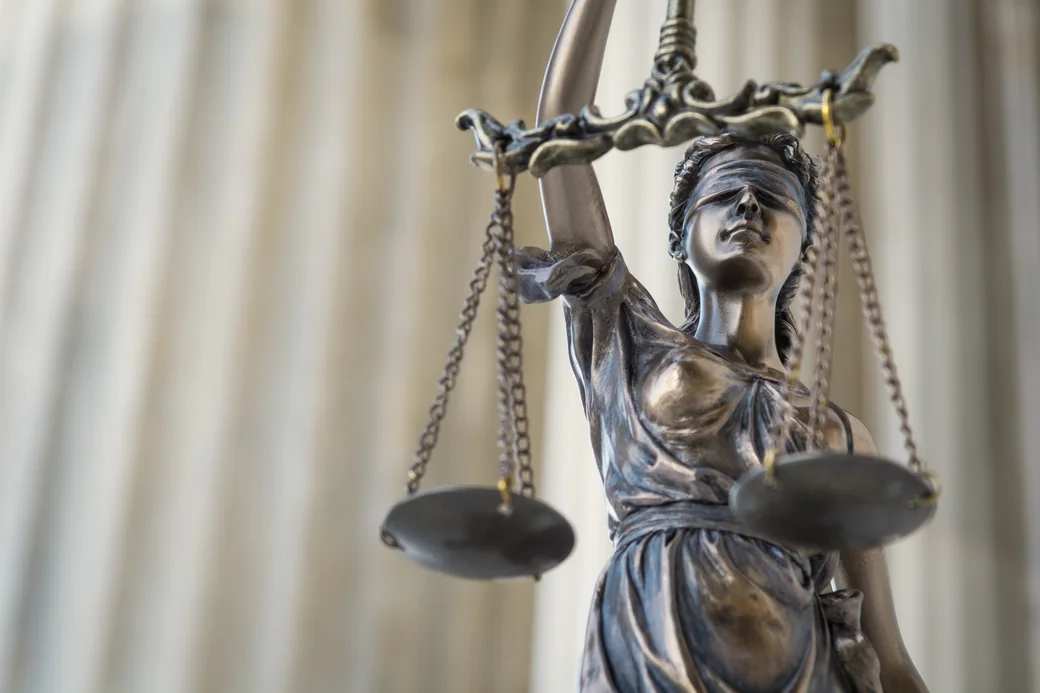 Estatua de la justicia con los ojos vendados sosteniendo la balanza